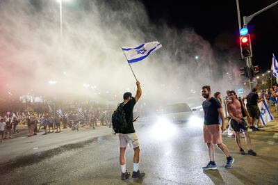 Israeli police use a water cannon to disperse demonstrators blocking a road in Jerusalem. AP