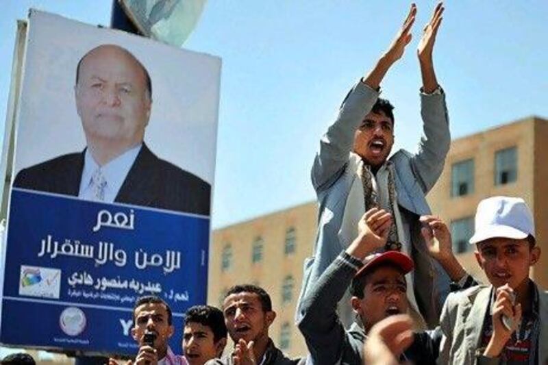 Yemeni protesters in Sanaa shout slogans on Friday next to an election campaign billboard featuring Yemeni Vice President Abdrabu Mansur Hadi during a demonstration to encourage participation in Tuesday's presidential elections in Sanaa.