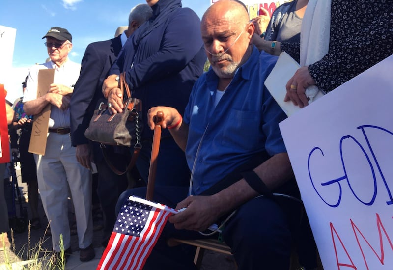 FILE - In this June 26, 2017 file photo Kadhim Al-bumohammed, center, an Iraqi refugee in the U.S., listens to speakers at an Albuquerque, N.M., rally in his honor. Al-bumohammed an Iraqi Muslim refugee who trained U.S. troops going to Iraq and is now facing deportation is seeking sanctuary inside an Albuquerque church. Al-bumohammed decided to skip his immigration hearing Thursday, July 13, where he was expected to be detained. (AP Photo/Russell Contreras, File)