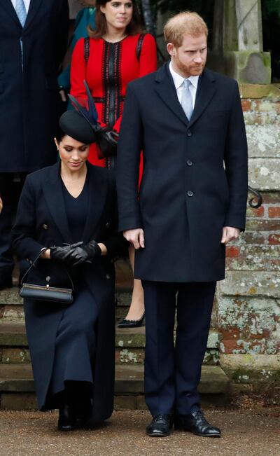 Britain's Prince Harry, stands with Meghan, Duchess of Sussex as she does a curtsy to Britain's Queen Elizabeth II as she leaves in a car after attending the Christmas day service at St Mary Magdalene Church in Sandringham in Norfolk, England, Tuesday, Dec. 25, 2018. (AP Photo/Frank Augstein)