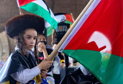 A Jewish boy holding a Palestine flag takes part in a protest in support of Palestinians following a flare-up of Israeli-Palestinian violence, in the Queens borough of New York City, New York, U.S., May 22, 2021. REUTERS/Jeenah Moon TPX IMAGES OF THE DAY
