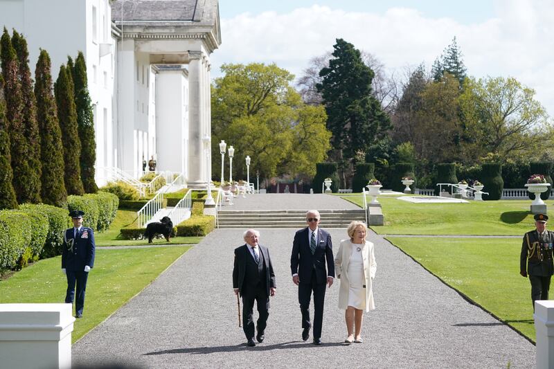 Mr Higgins and his wife Sabina walk with Mr Biden at Aras an Uachtarain. PA