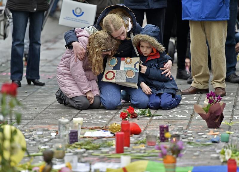 A woman and children mourn for the victims of the bombings at the Place de la Bourse in the centre of Brussels on March 23, 2016. Martin Meissner / Associated Press