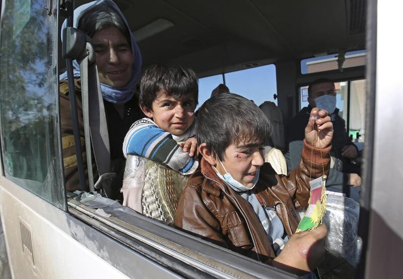 Yazidi boys, suffering from several infections from mosquito bites while held by ISIL, wait with their mother inside a bus outside the northern Iraqi city of Kirkuk after having been freed by the extremists. Bram Janssen/AP Photo