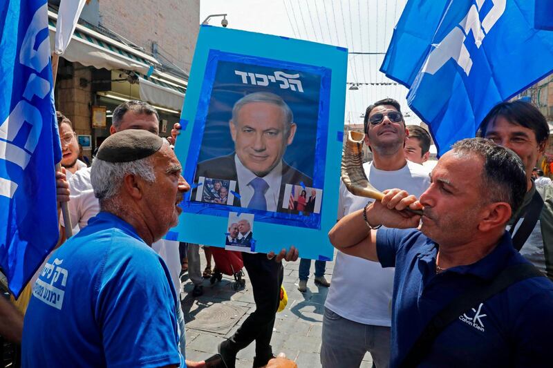 Supporters of Israeli Prime Minister Benjamin Netanyahu march at the Mahane Yehuda Market in Jerusalem on September 13, 2019.  Benjamin Netanyahu has become Israel's longest-serving prime minister and is fighting his second election in five months in the upcoming September 17 elections. / AFP / MENAHEM KAHANA
