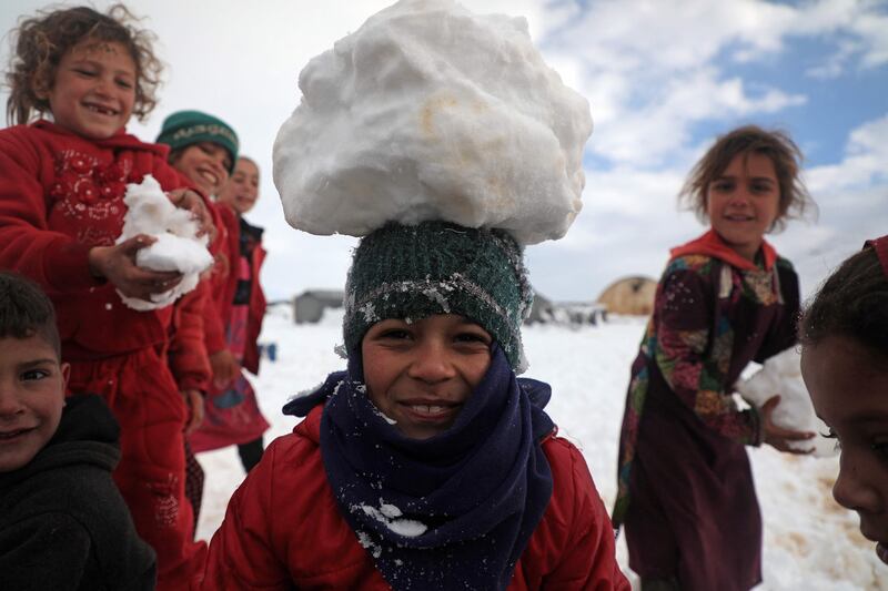 Children at a camp for internally displaced people in Raju have fun in the snow. AFP