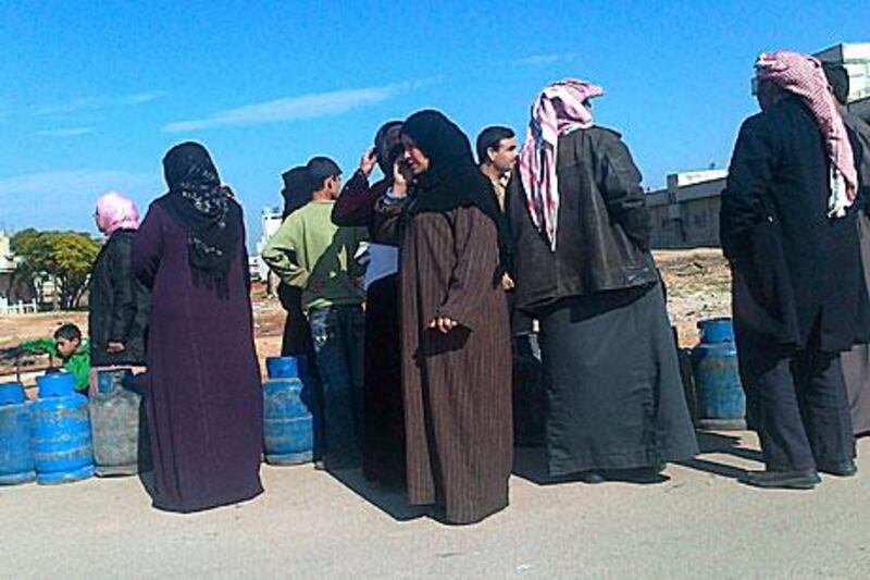 People queue to refill empty cooking gas cylinders in Deir Balaba near Homs last week.