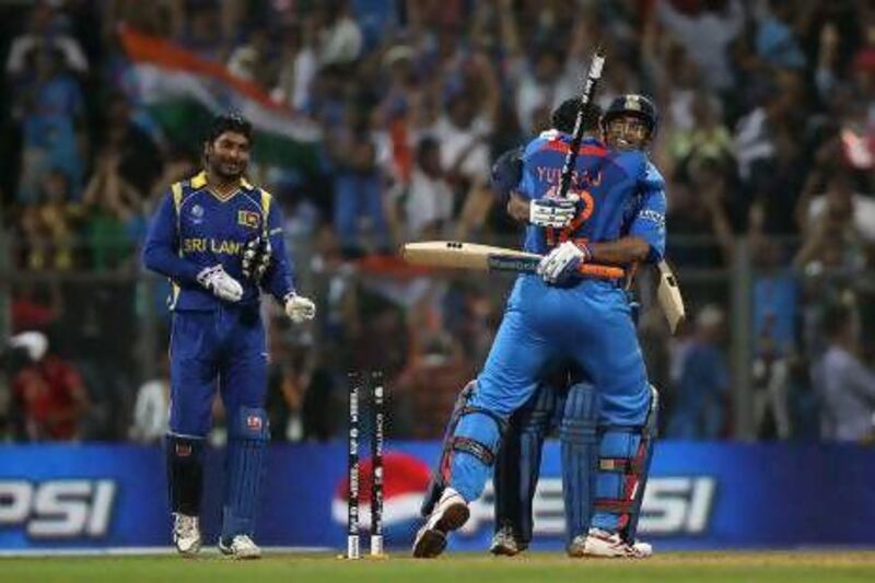 MUMBAI, INDIA - APRIL 02: MS Dhoni (R) of India celebrates with Yuvraj Singh after hitting a six to win by six wickets as Kumar Sangakkara (L) captain of Sri Lanka looks on during the 2011 ICC World Cup Final between India and Sri Lanka at Wankhede Stadium on April 2, 2011 in Mumbai, India. (Photo by Michael Steele/Getty Images)