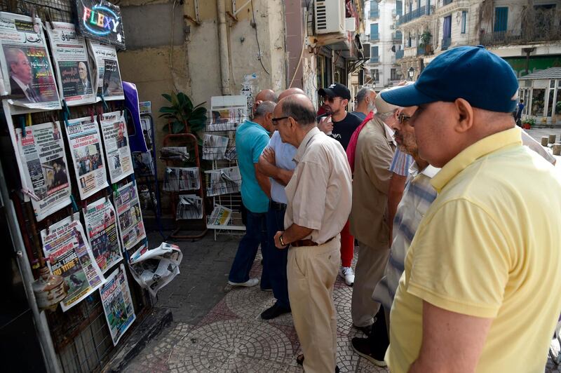 People view the covers of national and foreign newspapers, with the announced Algerian presidential election date dominating headlines, at a stand in Algeria's capital Algiers.  AFP