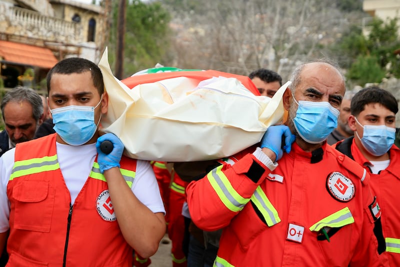Medics carry the body of one of the seven victims. EPA