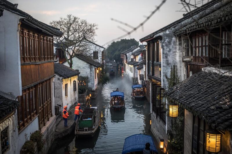A Chinese woman steers a boat in a canal in Zhouzhuang, China. EPA