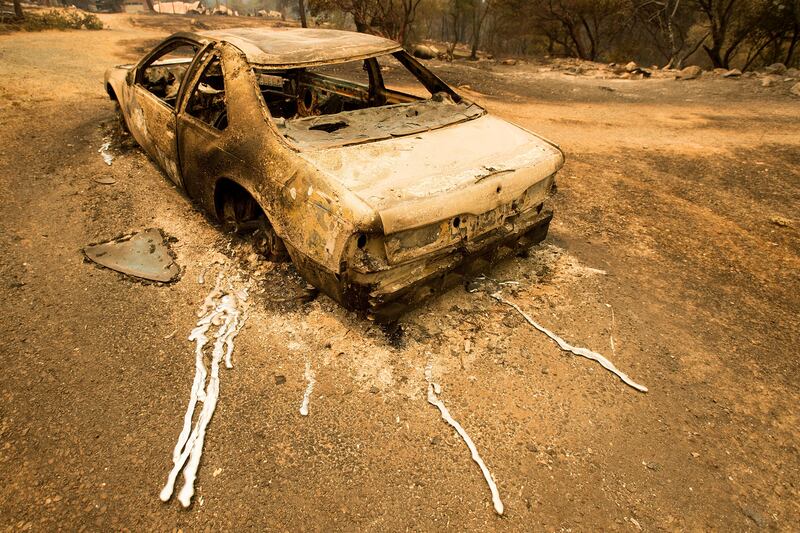A scorched car rests next to a residence leveled by the Detwiler fire near Mariposa. Noah Berger / AP Photo