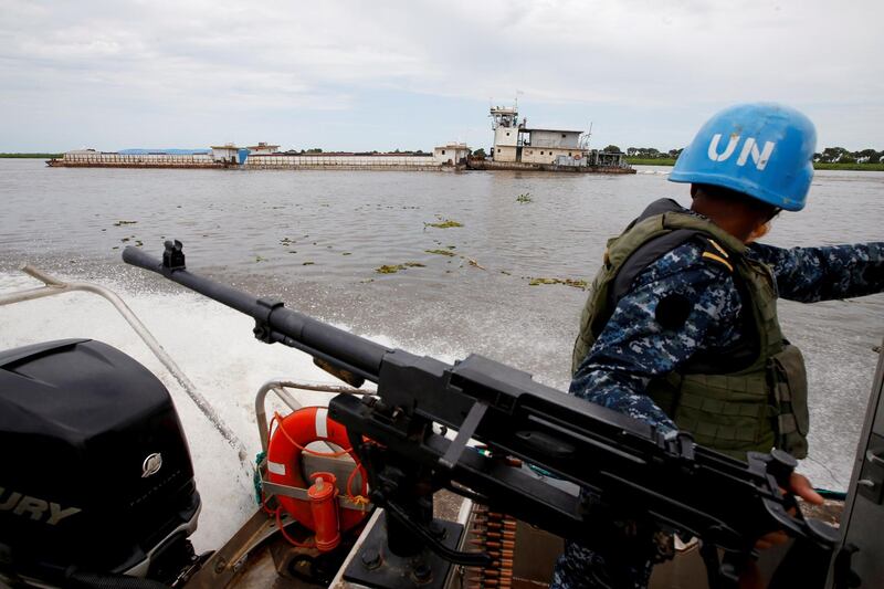A Bangladeshi Navy peacekeeper from UNMISS (UN Mission in South Sudan) looks at a World Food Program barge while patrolling on the white Nile near the town of Malakal, in the Upper Nile state of South Sudan, September 8, 2018. REUTERS/Baz Ratner    SEARCH "MALAKAL BAZ" FOR THIS STORY. SEARCH "WIDER IMAGE" FOR ALL STORIES.