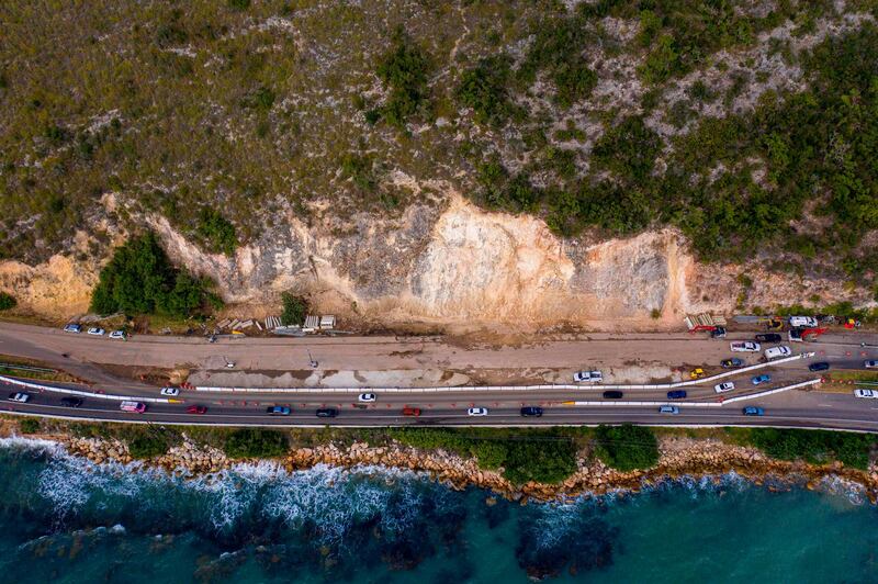 Cars drive through an area on Highway 2 that was heavily affected by a landslide after after a powerful earthquake hit the island in Ponce, Puerto Rico.  AFP