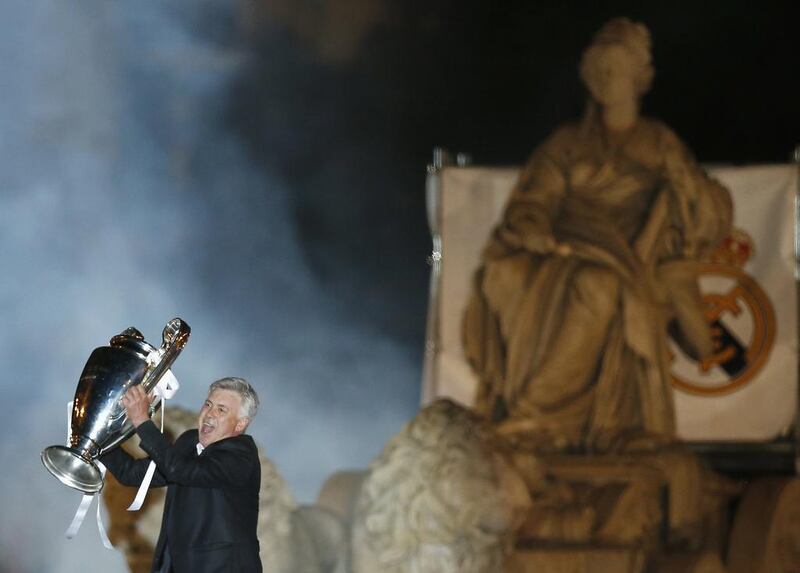 Real Madrid manager Carlo Ancelotti celebrates with the trophy after winning their Champions League final on Saturday. Behind him, the Cibeles statue that stands at Cibeles Square in Madrid is seen. Andrea Comas / Reuters / May 24, 2014