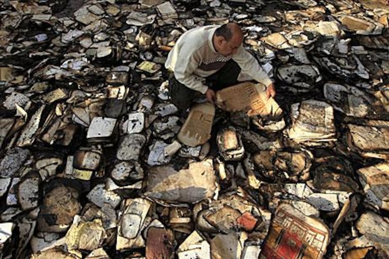A book restorer sifts through burnt and smoke-damaged books at the Institute of Egypt in Cairo after the centre caught fire during recent clashes between security forces and protesters.