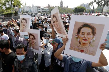 Demonstrators hold images of detained Myanmar State Counsellor Aung San Suu Kyi during a protest against the military coup. Fitch Solutions says that foreign direct investment to the country is likely to take a hit in the wake of rising political risk. EPA 