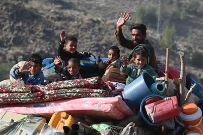 An Afghan refugee family waves from atop a lorry heading towards the Pakistan-Afghanistan Torkham border. AFP