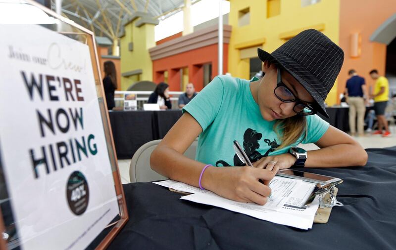 Job seeker Alejandra Bastidas fills out an application at a job fair, Tuesday, Oct. 3, 2017, at Dolphin Mall in Sweetwater, Fla. On Wednesday, Oct. 4, 2017, payroll processor ADP reports how many jobs private employers added in September. (AP Photo/Alan Diaz)