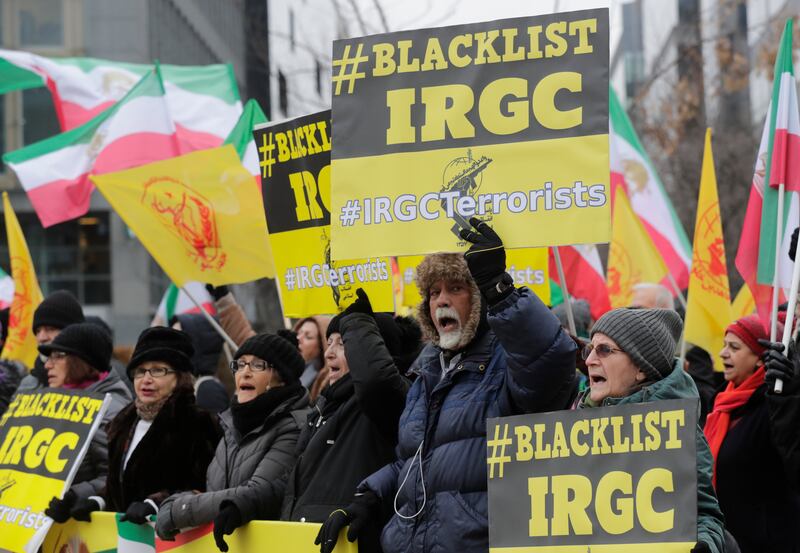 Iranian opposition supporters hold placards calling for the IRGC to be blacklisted. EPA