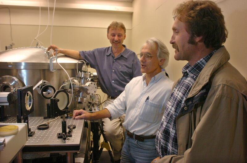 FILE - In this Monday, June 28, 2004 file photo, University of Michigan Professor Gerard Mourou, center, and fellow research scientists Anatoly Makisimchuk, left, and Victor Yanovsky talk about the potential of the laser dubbed Hercules that has been built over the past five years at the University of Michigan lab. American Arthur Ashkin, Canadian Donna Strickland, and French scientist Gerard Mourou win the 2018 Nobel Prize for work in laser physics. (AP Photo/The Ann Arbor News, Robert Chase, File)