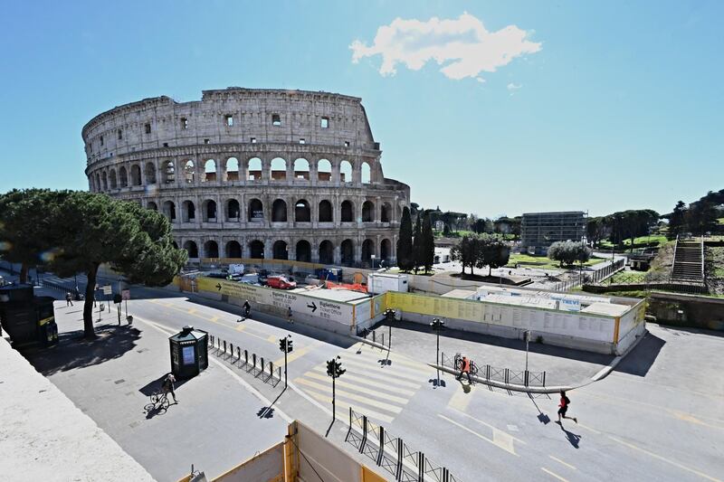 Streets are almost empty in front of the Ancient Colosseum in central Rome, as three-quarters of Italians entered a strict lockdown. AFP