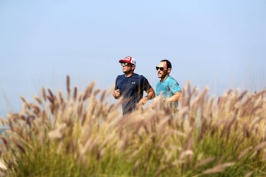 Two men jog on Jumeiah Public Beach in Dubai on February 6. Chris Whiteoak / The National