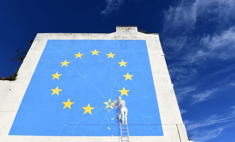 epaselect epa06920668 A view of a Brexit-inspired mural by anonymous British street artist Banksy depicting the European flag in Dover, Britain, 31 July 2018. The graffiti that appeared on a building near Dover's ferry terminal shows a worker removing one of the 12 stars from the EU flag.  EPA/FACUNDO ARRIZABALAGA