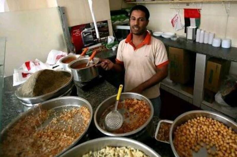 Mohammed Rashad, a 30-year-old Egyptian who works at Lazeez Coshari, a restaurant in Abu Dhabi named for the inexpensive popular vegetarian dish of a similar name, is working to pay for his legal studies with the hope of eventually returning home to work as a lawyer. Fatima Al Marzooqi/ The National