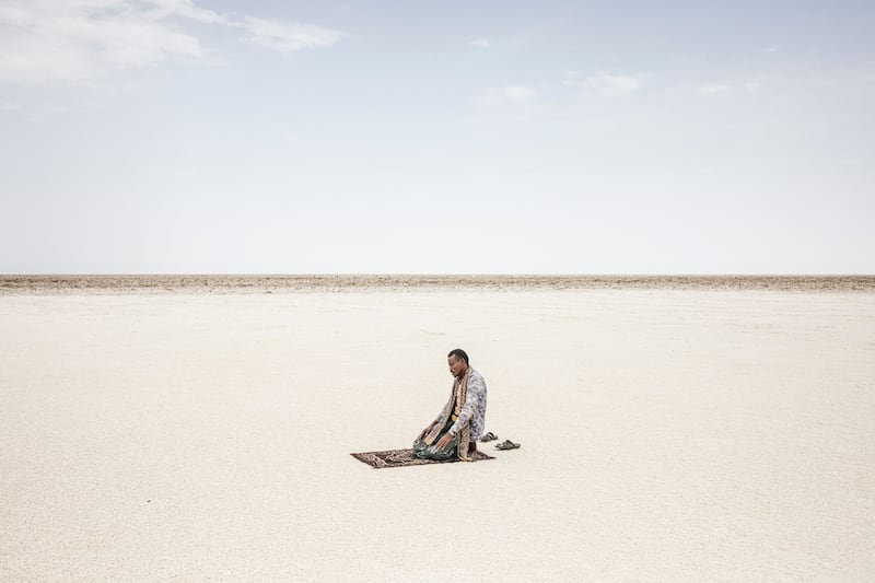 An Ethiopian man prays on the banks of Lake Karum, a salt lake in Afar Region, amid above-50° temperatures. AFP