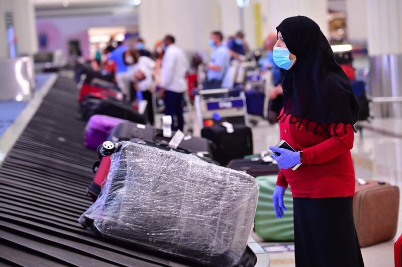 A tourist waits for her luggage at Dubai airport.  AFP