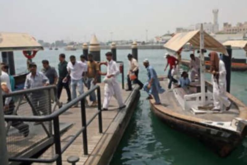 People disembark from an abra at the Bur Dubai station on the Dubai Creek