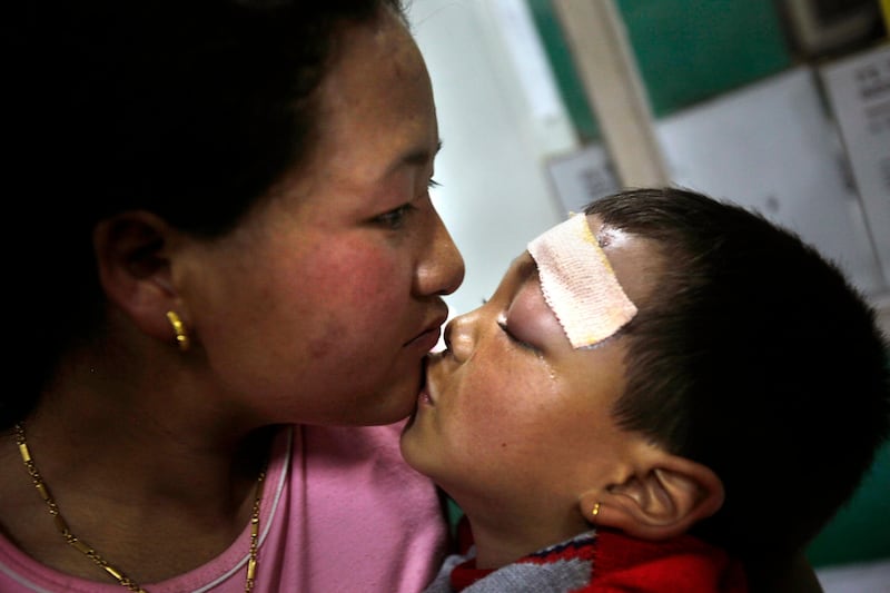 Jigmy Tamang, 6, an injured boy kisses his mother as he awaits medical treatment in a civil hospital in Gangtok, India, Tuesday, Sept. 20, 2011. Thousands of terrified survivors of a Himalayan earthquake that killed many people and shook parts of India, Nepal and China crowded Tuesday into shelters and relatives' homes or stayed out in the open for fear of aftershocks. (AP Photo/Anupam Nath) *** Local Caption ***  APTOPIX India Earthquake.JPEG-05d6d.jpg
