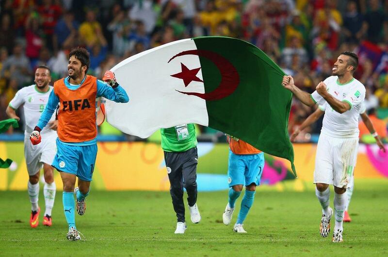 Algeria players Mohamed Zemmamouche, left and Essaid Belkalem hold aloft the Algerian flag after their 1-1 draw with Russia on Thursday at the 2014 World Cup, which put them through to the last-16. Julian Finney / Getty Images