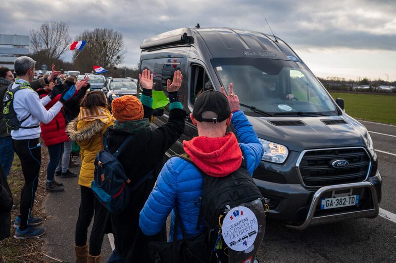 Supporters of the Freedom Convoy cheer participants leaving Strasbourg, north-east France. AFP