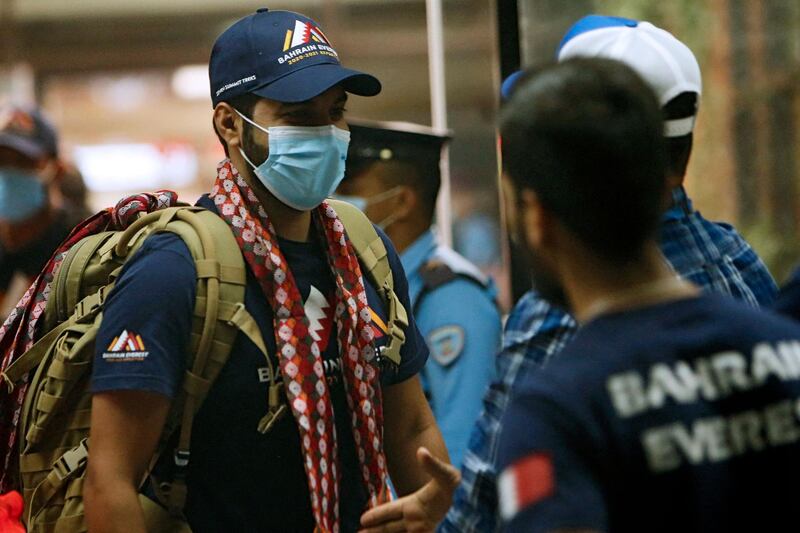 In this picture taken on March 15, 2021 Sheikh Mohamed Hamad Mohamed Al Khalifa (L), who is planning to climb the Mount Everest, arrives at Tribhuvan International Airport in Kathmandu. Nepal is investigating how a Bahraini prince planning to climb Mount Everest brought 2,000 coronavirus vaccine doses to the country without prior approval, authorities said. / AFP / NIshant S. GURUNG
