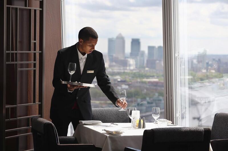 A waiter lays a table ahead of a reception on the 35th floor of the Shangri-La Hotel. Dan Kitwood / Getty Images
