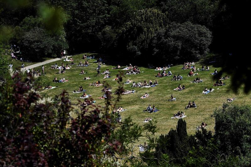 People enjoy the sun at the Buttes Chaumont Park in Paris, on the first day of its reopening.  AFP