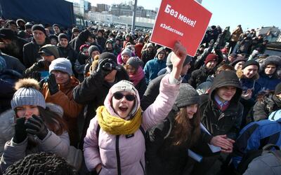 Demonstrators shout slogans holding a poster which reads "Elections without me! Strike." during a rally in Vladivostok, Russia, Sunday, Jan. 28, 2018. Opposition politician Alexey Navalny calls for nationwide protests following Russia's Central Election Commission's decision to ban his presidential candidacy. (AP Photo/Aleksander Khitrov)