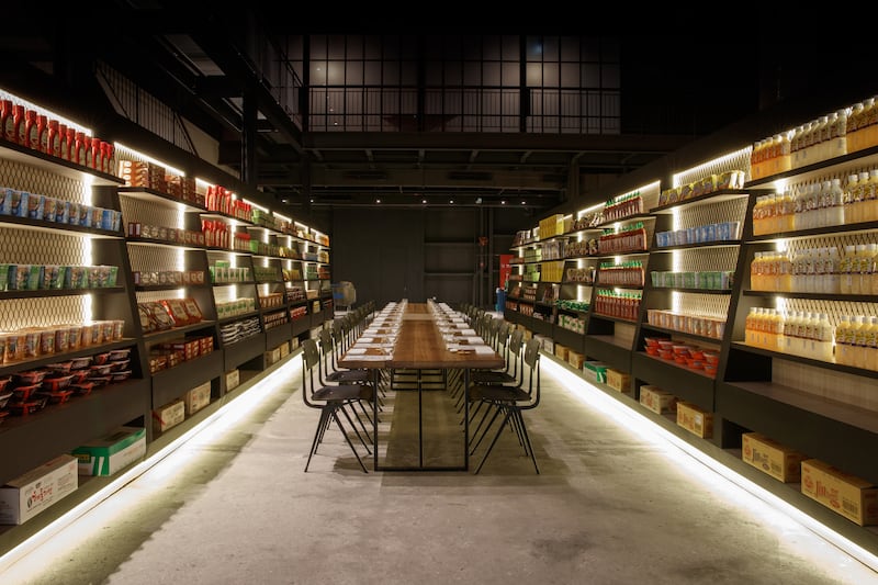 A supper club table set up in the middle of recreated supermarket aisle. Photo: Inked