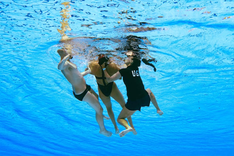 Anita Alvarez is helped from the pool after fainting at the World Aquatics Championships. AFP