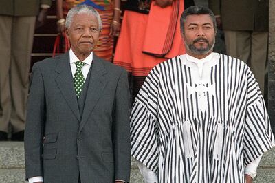 (FILES) In this file photo taken on July 09, 1998 South African President Nelson Mandela (L) and President of Ghana Jerry Rawlings (R) stand, listening to the national anthems being played on Rawlings arrival at the Union building in Pretoria. Rawlings arrived yesterday for a two day state visit to South Africa.  Ghana's former leader Jerry Rawlings, who towered over the West African nation for two decades first as military ruler and then as elected president, has died aged 73, his party said on November 12, 2020. / AFP / Odd ANDERSEN
