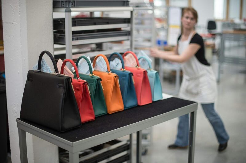 (FILES) In this file photo taken on March 31, 2016 a woman works in the Hermes workshop on the eve of the inauguration day, in Hericourt, eastern France. The United States on July 10, 2020 unveiled heavy import duties on France, including French cosmetics and handbags, in retaliation for the country's tax on American tech giants, but will hold off on collecting the fees to allow time for the dispute to be resolved. / AFP / SEBASTIEN BOZON
