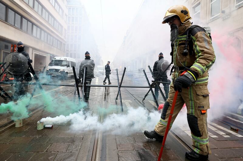 A firefighter holds a walking stick at a protest in Brussels. Reuters