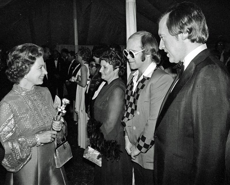 Sir Elton and television personality Sir David Frost are presented to Queen Elizabeth II at Windsor in 1977. PA