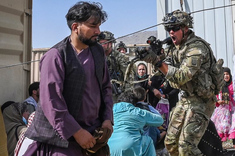 A US soldier points his gun at a man at Kabul airport on August 16, 2021, after a swift end to Afghanistan's 20-year war. Thousands of people mobbed the airport in a bid to flee. AFP
