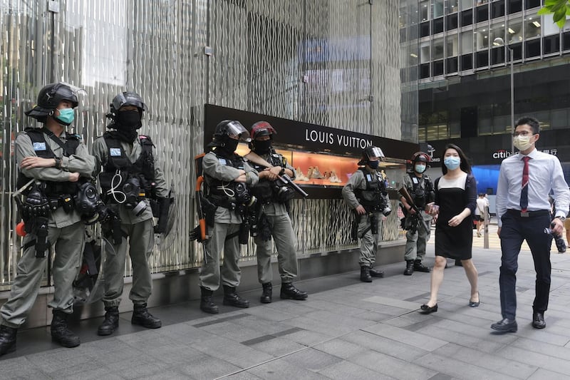 Riot police stand in front of a Louis Vuitton luxury goods store, operated by LVHM Moet Hennessy Louis Vuitton SE, in the Central district in Hong Kong, China, on Thursday, May 28, 2020. Chinese lawmakers approved a proposal for sweeping new national security legislation in Hong Kong, defying a threat by U.S. President Donald Trump to respond strongly to a measure that democracy advocates say will curb essential freedoms in the city. Photographer: Roy Liu/Bloomberg