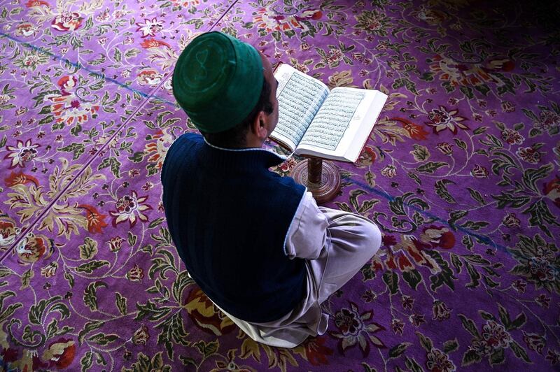 A Kashmiri Muslim reads the Quran at the Sheikh Abdul Qadir Geelani Shrine during the holy month of Ramadan in Srinagar.  AFP
