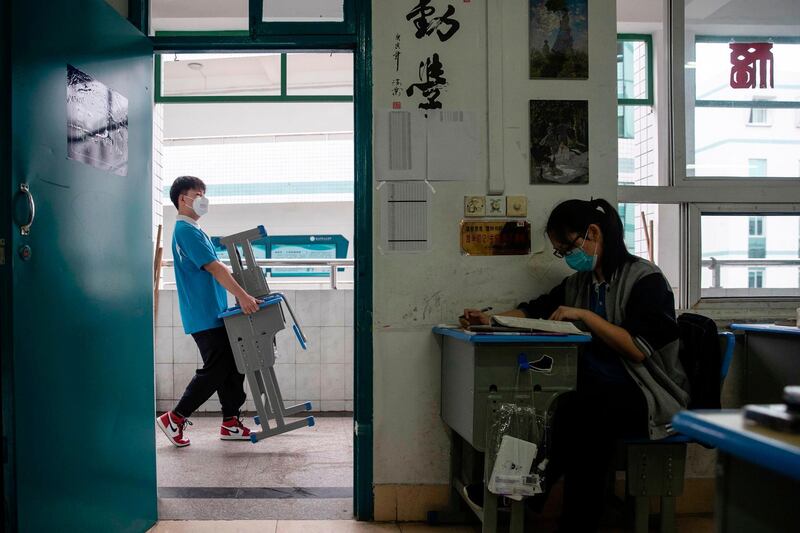 A boy moves a desk and chair at a high school in Wuhan in China's central Hubei province. AFP