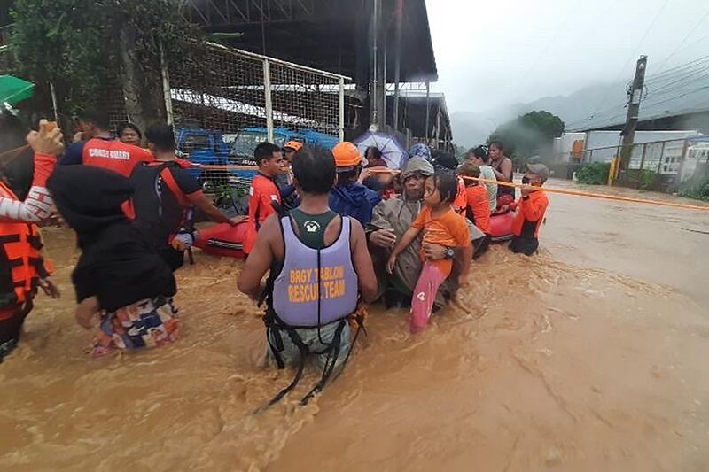 Residents are helped to higher grounds. Photo: AFP